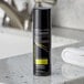 A black bottle of TRESemme Extra Hold hair spray with white text on a counter.