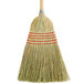 A Carlisle janitor corn broom with a wooden handle.