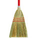 A Carlisle 3-stitch lobby corn broom with a red handle and green bristles.