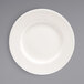 A Front of the House European white porcelain plate with a circular pattern on the rim.