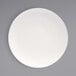 A Front of the House European white porcelain plate with a white rim on a gray surface.
