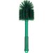 A close-up of a green Carlisle Sparta multi-purpose cleaning brush with bristles.