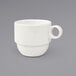 A close-up of a Front of the House European white porcelain coffee mug with a handle.