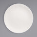 A Front of the House European white porcelain plate with a spiral pattern on the edge.