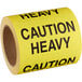 A roll of white Lavex caution labels with the words "Caution Heavy" in yellow.