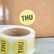 A roll of Lavex Thursday lime matte paper labels with black text on a cardboard box.