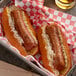 A basket of hot dogs made with Beyond Meat Original Bratwurst with sauerkraut and mustard.