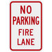 A white sign with red text that says "No Parking / Fire Lane" and has a red diamond border.