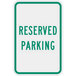 A white aluminum sign with green text that says "Reserved Parking" on a white background.