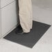A person standing on a black Guardian anti-fatigue floor mat.