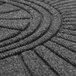 A close up of a charcoal diamond floor mat with a circular design.