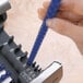 A person using a Fellowes Galaxy electric binding machine to bind a document with a blue plastic comb.