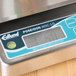 An Edlund digital portion scale with a digital display on a counter.