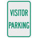 A white and green sign that says "Visitor Parking" in green text.