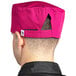 A person wearing an Uncommon Chef Epic Berry chef's hat with a pink brim and a black back.