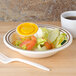 A Thunder Group Arcadia melamine salad bowl filled with salad on a counter.