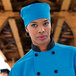 A woman in a blue chef's hat and coat.