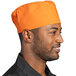 A man wearing an orange Uncommon Chef Epic Carrot chef skull cap.