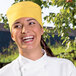 A woman wearing an Uncommon Chef Epic Sunflower chef skull cap.