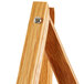 A wooden Aarco easel with a screw on the top.