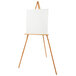 A white canvas on a wooden easel.