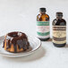 A chocolate cake with a bottle of Nielsen-Massey Pure Organic Peppermint Extract on the counter.
