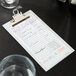 A Choice clipboard with green and white guest check receipts on it.