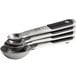 A stack of OXO stainless steel measuring spoons with black grips and a silver magnetic handle.