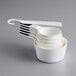 A stack of white OXO Good Grips measuring cups with white handles.