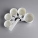 A group of white OXO Good Grips measuring cups with handles.