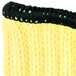 A close up of a yellow knitted glove with a black brim.