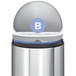A white simplehuman trash can liner in a silver simplehuman trash can with the B logo on it.