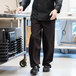 A man wearing Uncommon Chef black pinstripe chef pants.