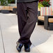 A person in Uncommon Chef pinstriped chef pants standing outside.