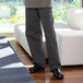 A man wearing Uncommon Chef gray pinstripe chef pants standing in a room.
