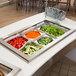 A Vollrath Super Pan with a variety of vegetables in it on a buffet.