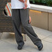 A person standing on a patio wearing Uncommon Chef grey pants.