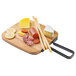 A Tablecraft rectangular acacia wood serving board with cheese, sausage, and crackers on it.