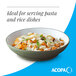 A moss green matte stoneware pasta bowl filled with pasta and garnished with herbs and cheese.