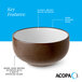 A stoneware bowl with a warm, dark brown matte speckled exterior, a glossy white interior, and a dark banded edge.