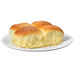 Two Krusteaz yeast rolls on a white plate.