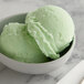 A bowl of mint I. Rice Italian ice with two scoops.