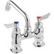 a silver faucet with red knobs