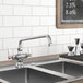 A Waterloo deck-mounted faucet above a kitchen sink with a chalkboard on the wall.