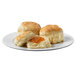 A plate with three Krusteaz Southern-Style biscuits and jam on a white background.