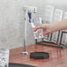 A person using a Waterloo countertop glass filler to pour water into a glass on a counter.
