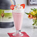 A glass of pink I. Rice strawberry milkshake with strawberries and sprinkles.
