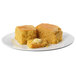 Two pieces of Krusteaz Southern-Style cornbread on a plate with butter.