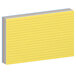 A stack of Oxford index cards with yellow, blue, green, and red lines on white index cards.