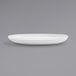 A white Front of the House Harmony oval porcelain plate on a gray surface.
